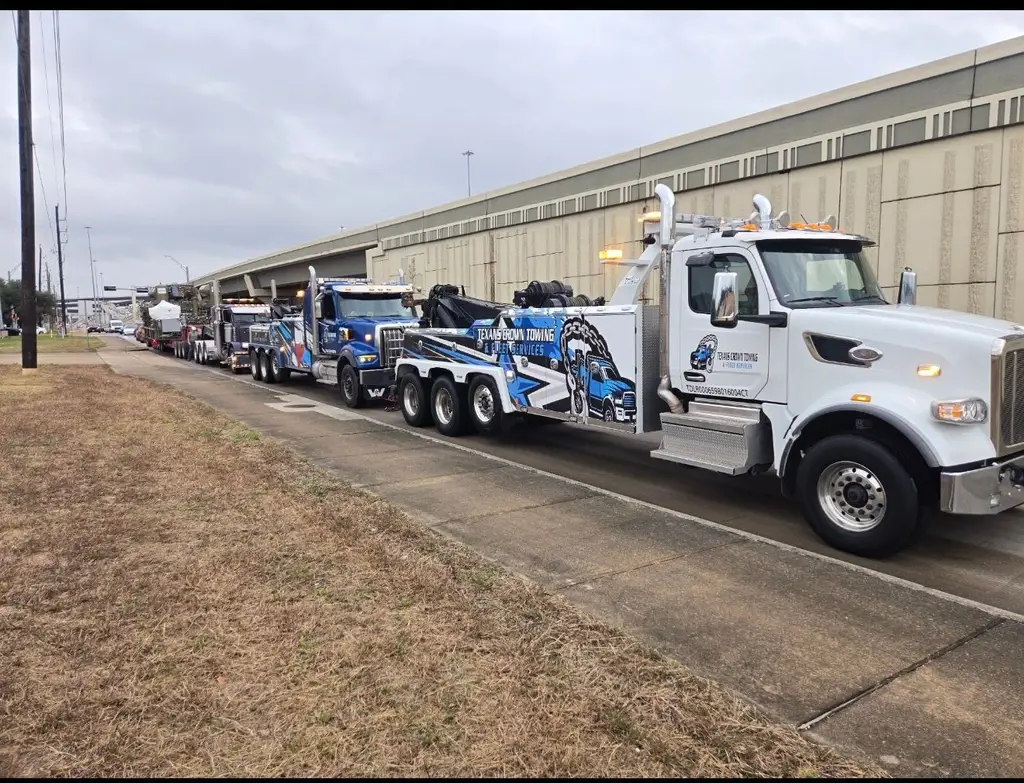 Row of heavy wreckers and trucks lined up outside the shop