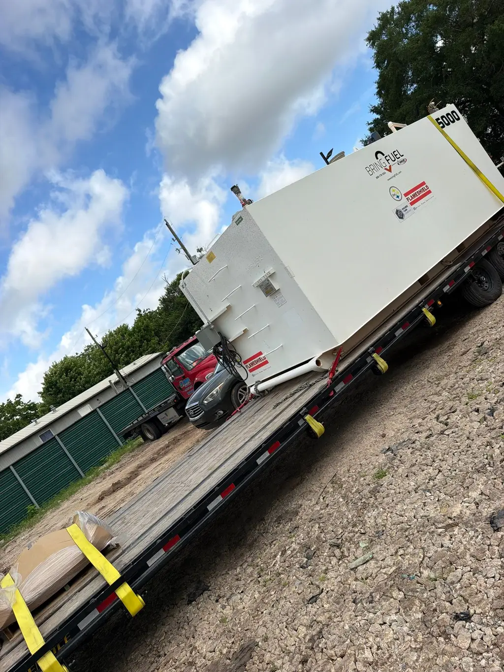 Large fuel and generator skid loaded on a low-boy trailer