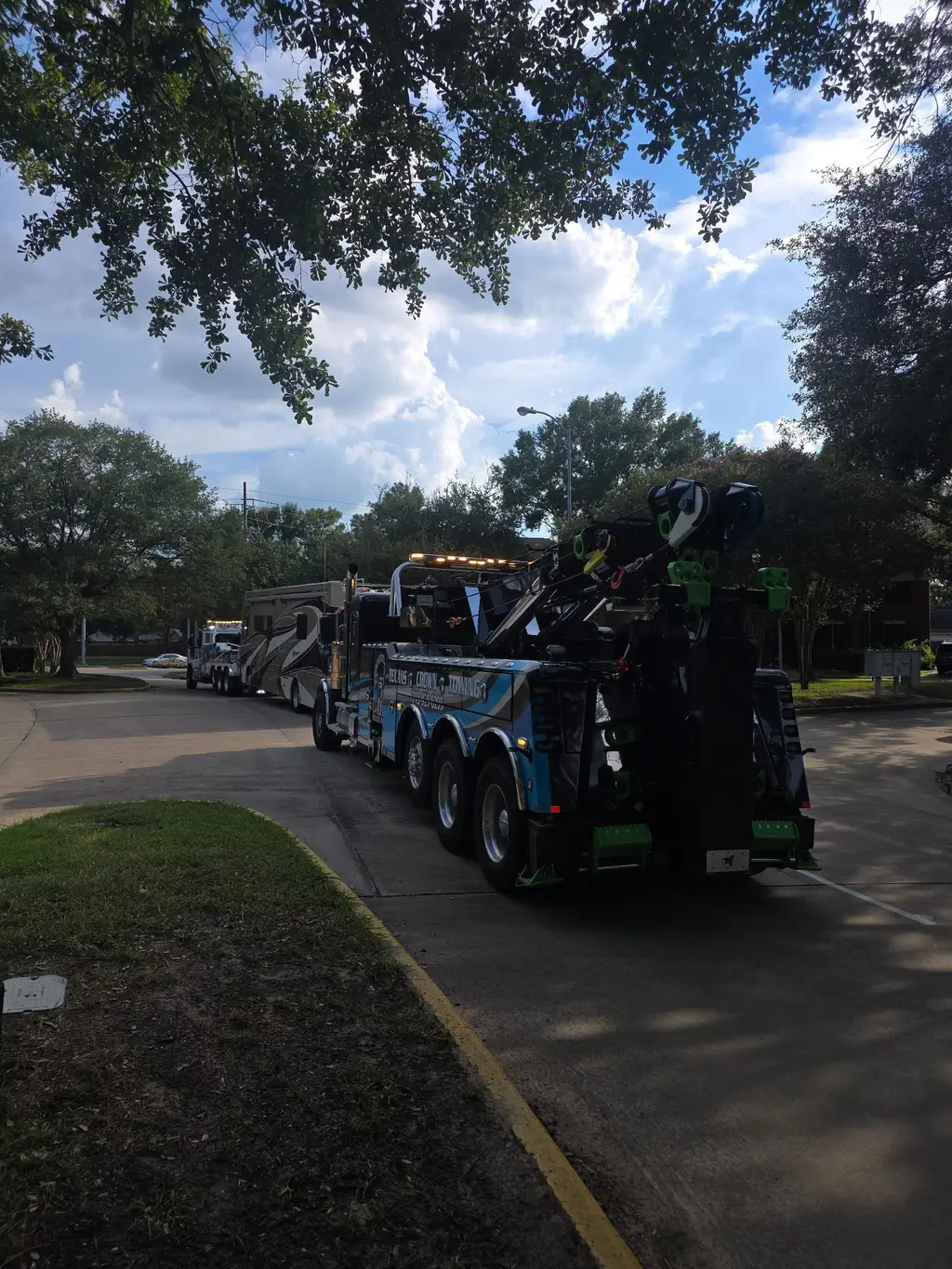 Rotator towing a Class A motorhome down a residential street